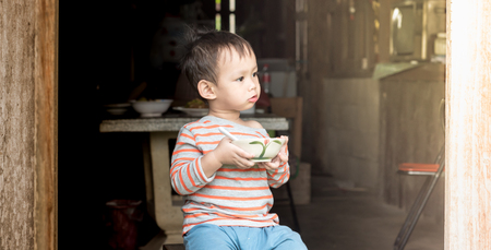 Asian baby boy eating rice by spoon by him selfの写真素材