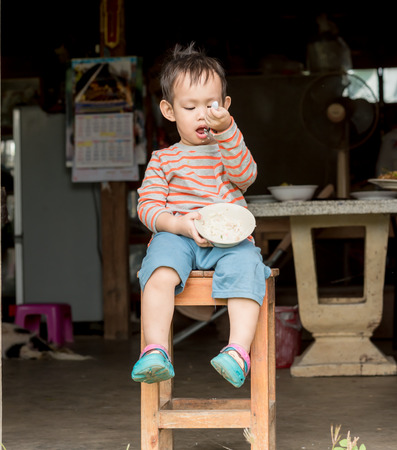Asian baby boy eating rice by spoon by him selfの写真素材