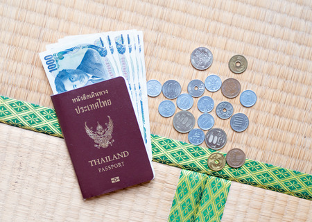Thailand passport put together with Japanese coins and banknoteの写真素材