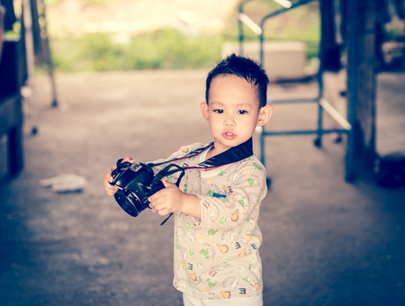 Handsome Asian kid take a photo by DSLR cameraの写真素材