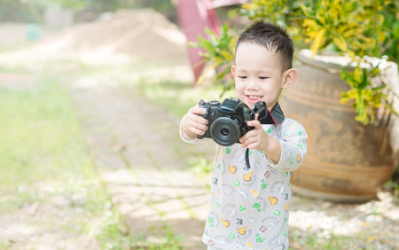 Handsome Asian kid take a photo by DSLR cameraの写真素材