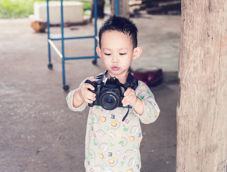 Handsome Asian kid take a photo by DSLR cameraの写真素材