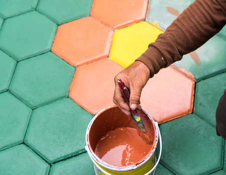 masonry worker painting paving block by color air brush and hand brushの写真素材