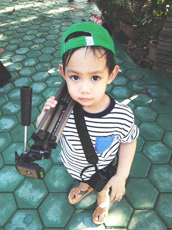 Asain kids carry camera tri podの写真素材