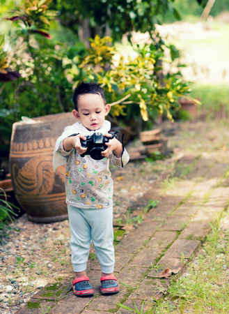 Handsome Asian kid take a photo by DSLR camera の写真素材
