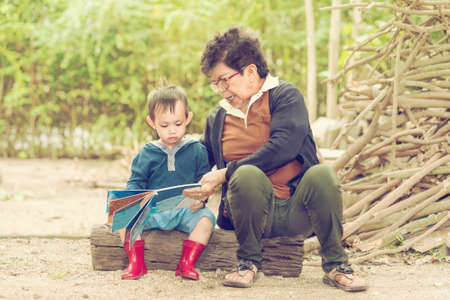 grand mother teach boy to read bookの写真素材