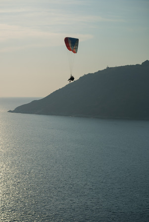Beautiful island landscape paraglider flying over sea at the sunset time of Phuket, Thailandの写真素材