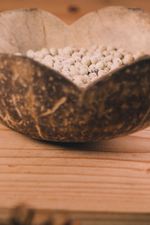 Close-up shot pepper with wood spoon on wooden backgroundの写真素材