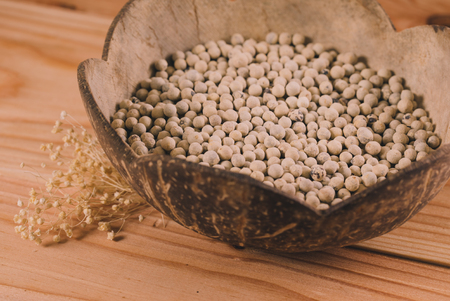 Close-up shot pepper with wood spoon on wooden backgroundの写真素材