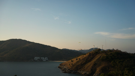Beautiful island landscape paraglider flying over sea at the sunset time of Phuket, Thailandの写真素材