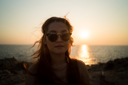 Happy woman Sunset at the sea with rocks in foreground , khao-laem-ya Rayong Thailandの写真素材