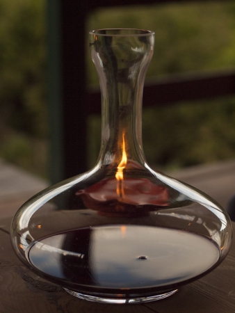 Decanter with red wine and candleの写真素材