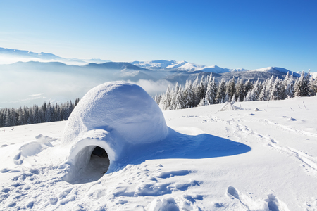 Marvelous huge white snowy hut, igloo  the house of isolated tourist is standing on high mountain...