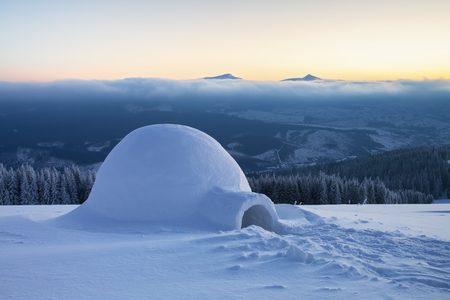 Marvelous huge white snowy hut, igloo the house of isolated tourist is standing on high mountain far away from the human eye.の写真素材