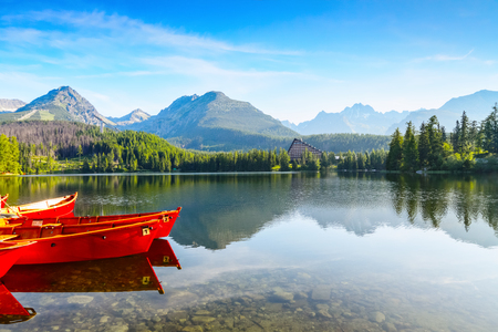 The picture captures the view of a person watching boats reverie, calm lake, fantastic mountains and the clouds floating across the skyの写真素材