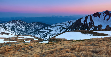 Panoramic view of the picks of high mountains covered with snow, meadow with the rocks, amazing sunrise. Eco resort Carpathians, Ukraine, Europe.の写真素材