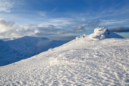 A man goes along the path with a backpack. Mysterious fantastic rocks frozen with ice and snow of...