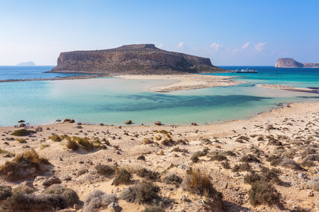 Scenery of sunny summer day with sand beach, turquoise sea and mountains. Blue horizon line. Place for tourists rest Balos lagoon, shore of Crete island, Greece. Ionian, Aegean and Libyan seas.の写真素材