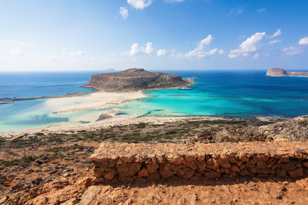 Scenery of sunny summer day with sand beach, turquoise sea and mountains. Blue horizon line. Place for tourists rest Balos lagoon, shore of Crete island, Greece. Ionian, Aegean and Libyan seas.の写真素材