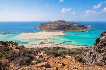 Scenery of sunny summer day with sand beach, turquoise sea and mountains. Blue horizon line. Place for tourists rest Balos lagoon, shore of Crete island, Greece. Ionian, Aegean and Libyan seas.の写真素材
