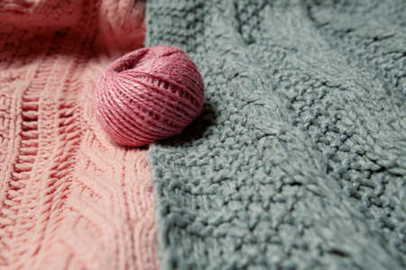 ball of pink wool on gray and pink knitted sweater. High quality photoの写真素材
