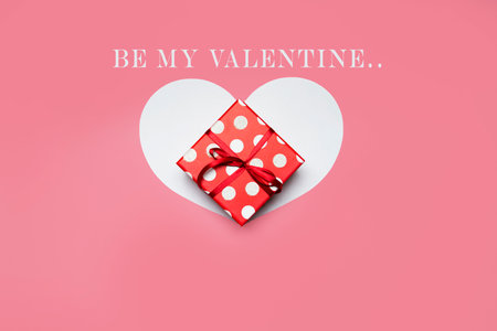 Gift box and heart on a pink background, be my valentine text. High quality photo
