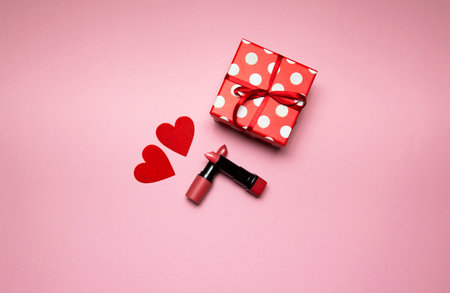 lipstick with a gift box and small heart on pink background. High quality photoの写真素材