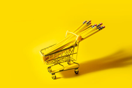yellow pencils in yellow cart on yellow background. High quality photo