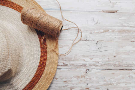 a skein of beige twine and a straw hat on a wooden background. twine for needlework. High quality photoの写真素材