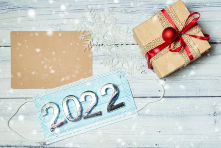 christmas decorations, medical mask with numbers 2022 on wooden background. High quality photoの写真素材