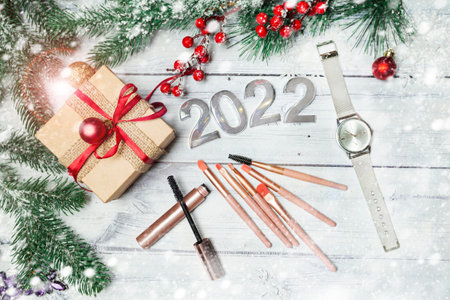 christmas background with christmas gift, makeup brushes and mascara with snowflakes and decorations on wooden backdrop. cosmetic gifts concept. High quality photoの写真素材