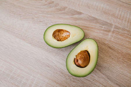 A half of avocado on a wooden board. High quality photoの写真素材