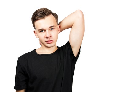portrait white young guy model dressed in a black t-shirt looking at the camera on white isolaed backgroundの写真素材