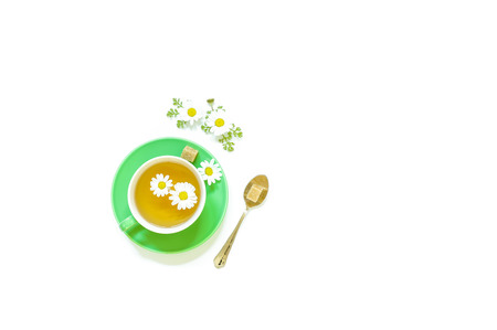 Chamomile tea in green cup and spoon with sugar isolated on white background. Chamomile tea. Horizontal. View from above.の写真素材