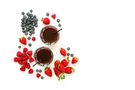 Two glasses of berries juice from strawberries, raspberries, blueberries and ingredients isolated on white background, copy space. Horizontal. Top view.の写真素材
