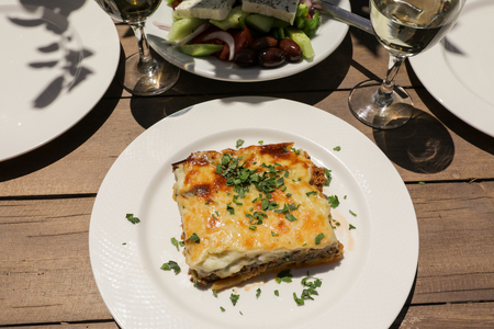 Traditional moussaka with eggplants, ground beef and potatoes in greek tavern. Horizontal. Daylight.の写真素材