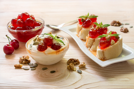 A bowl of greek yogurt and sandwiches with sugared cherry fruits.の写真素材