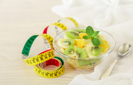 Kiwi, orange, banana fruit salad bowl diet concept on the white background. Horizontal. Daylight. Close-up.の写真素材