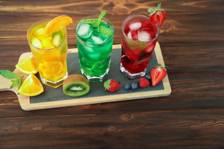 Three glasses of different cold summer drinks or refreshing cocktails yellow, green, red in toxic colors.の写真素材