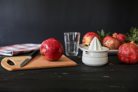 Preparing to make fresh pomegranate juice, ingredients, kitchenware on black woodenの写真素材