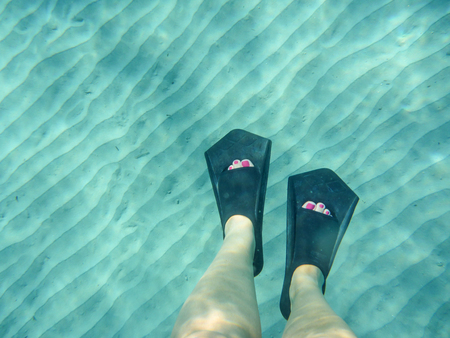 Female legs with flippers underwater view of the beautiful Skala beach of Kefalonia island, Ionian...