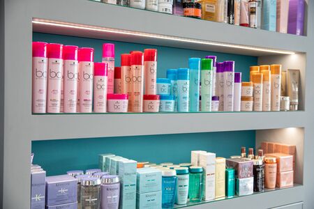 ATHENS, GREECE - FEBRUARY 18, 2020: Different bottles of shampoos, conditioners and other hair care products on a showcase at the beauty shop. Horizontal. Daylight.のeditorial素材