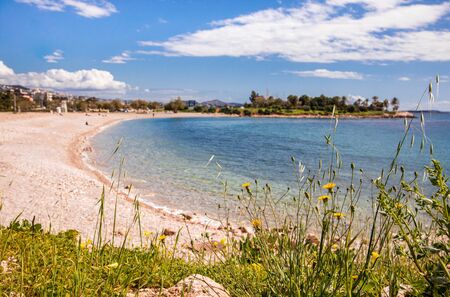 Beautiful spring seascape with calm sea, pebbles beach, blue sky of suburb in South Athens located...