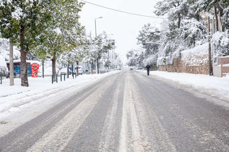 Dangerous driving in a snowstorm through the snowy streets of the Athens city, Greece, 16th of February 2021.のeditorial素材
