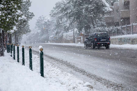 Dangerous driving in a snowstorm through the snowy streetsの写真素材