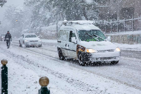 Dangerous driving in a snowstorm through the snowy streets of the Athens city, Greece, 16th of February 2021.のeditorial素材