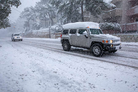 Dangerous driving in a snowstorm through the snowy streets of the Athens city, Greece, 16th of...