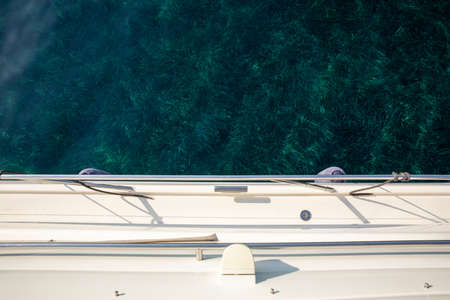 Crystal clear water with seaweeds on the sea bottom off the coast of Kastos island, Ionian sea, Greece in summer. Photo taken from the yacht. View from above.の写真素材