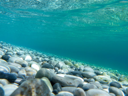 UNDERWATER sea level photo. Turquoise crystal clear water, pebbles of Agia Kyriaki beach in Kyparissi Laconia, Greece.の写真素材