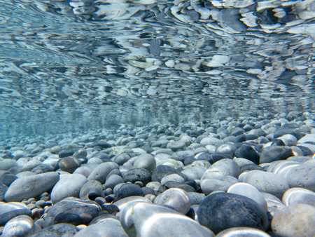 UNDERWATER sea level photo. Turquoise crystal clear water, pebbles of Agia Kyriaki beach in Kyparissi Laconia, Greece.の写真素材
